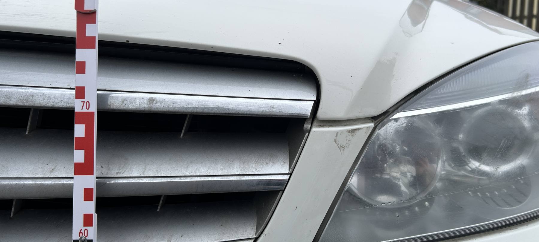 Oranger Fremdlack auf der dunklen Flanke eines Hyundai ix35, Beschädigung über beide Türen